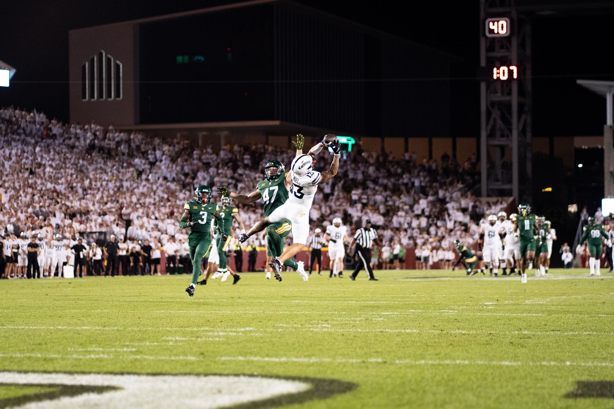 Football player making a diving catch over a defender