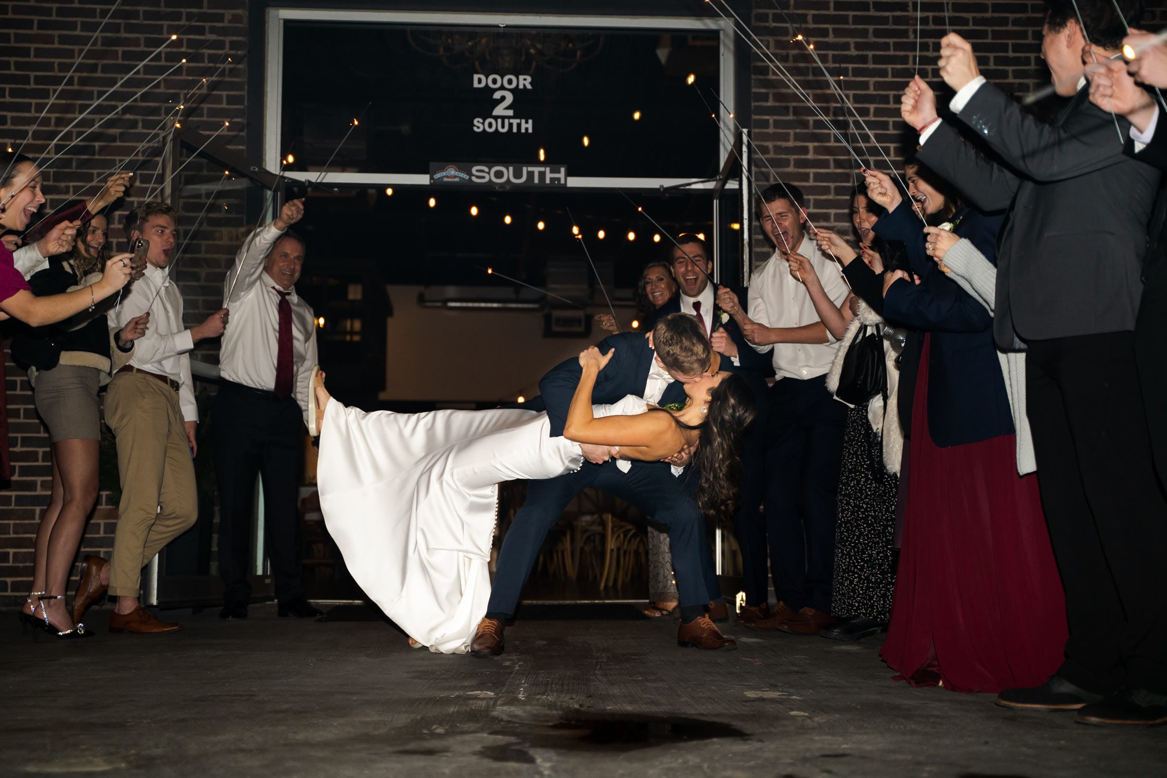 Bride and groom kissing during a sparkler send-off at their wedding reception